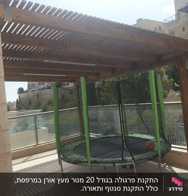 פרגולה מעץ עם טרמפולינה ירוקה על מרפסת